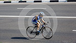 Female cyclist rides a racing bike on road