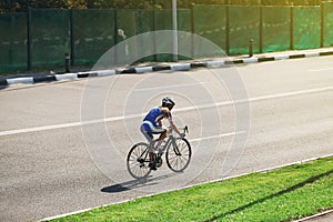 Female cyclist rides a racing bike on road