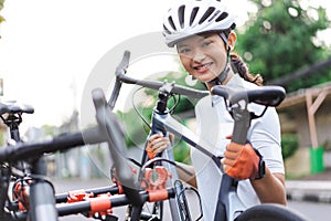 female cyclist unloading her road bicycle on a rack in the back of her car