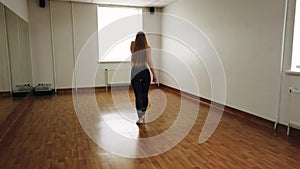 Female dancer training dance while rehearsing in dance studio.