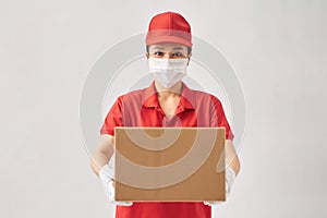 Female delivery courier in a red uniform smiling while working