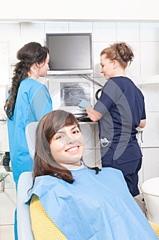 Female dentist and assistant analyzing x-ray at the dental clinic