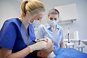 Female dentist checking patient dental occlusion photo