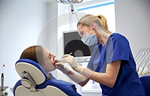 Female dentist checking patient girl teeth