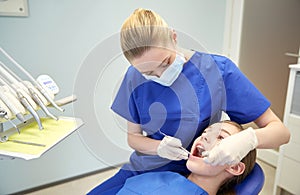 Female dentist checking patient girl teeth