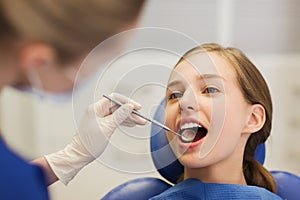 Female dentist checking patient girl teeth