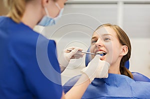 Female dentist checking patient girl teeth