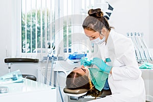 Female dentist checking up patient teeth with braces at dental clinic office. Medicine, dentistry concept. Dental