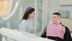 Female dentist communicates with patient. Dialogue in the dentist s office. Consult a doctor.