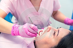 Female dentist curing a woman patient. Dental clinic and dentist appointment concept