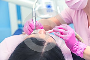 Female dentist curing a woman patient. Dental clinic and dentist appointment concept