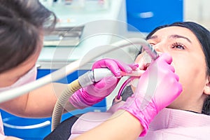 Female dentist curing a woman patient. Dental clinic and dentist appointment concept