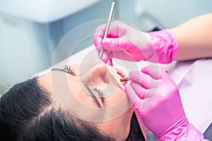 Female dentist curing a woman patient. Dental clinic and dentist appointment concept