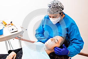 Female dentist doing an maxillofacial exam to a female patient