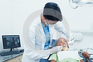 Female dentist examining boys teeth