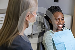 Female dentist examining woman patient with tools in dental clinic getting dental treatment