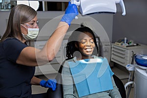 Female dentist examining woman patient with tools in dental clinic getting dental treatment
