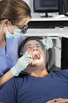 Female Dentist Giving Male Patient Check Up