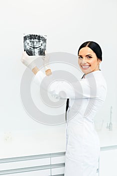 Female Dentist Looking at Dental Xray in Clinic