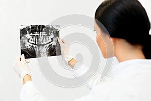 Female Dentist Looking at Dental Xray in Clinic