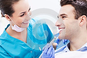 Female dentist with male patient photo