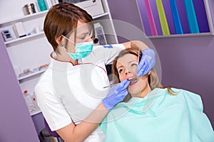 Female dentist in mask and young female patient