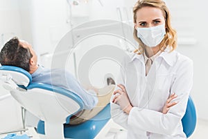 Female dentist in medical mask in modern