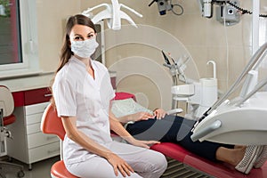 Female dentist near the patient in the dental chair