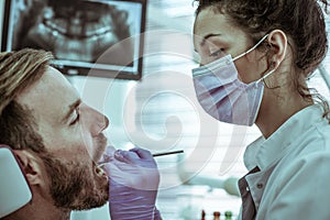 Female dentist operate on a patient mouth.