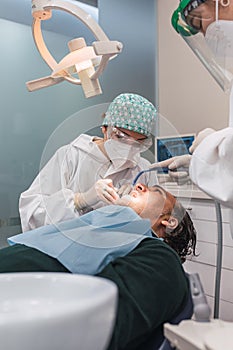 Female dentist with a patient in her office. Patient with open mouth and woman dentist working. dental health concept