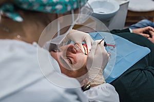 Female dentist with a patient in her office. Patient with open mouth and woman dentist working. dental health concept