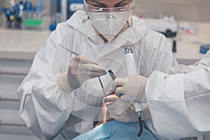 Female dentist with a patient in her office. Patient with open mouth and woman dentist working. dental health concept