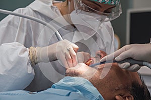 Female dentist with a patient in her office. Patient with open mouth and woman dentist working. dental health concept