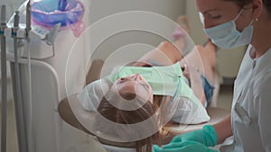 Female dentist preparing for checking up patient teeth with braces at dental clinic office. Medicine, dentistry concept