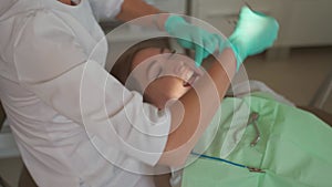 Female dentist removing braces patient teeth at dental clinic office. Medicine, dentistry concept. Dental equipment