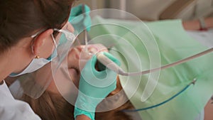 Female dentist removing braces patient teeth at dental clinic office. Medicine, dentistry concept. Dental equipment