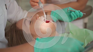 Female dentist removing braces patient teeth at dental clinic office. Medicine, dentistry concept. Dental equipment