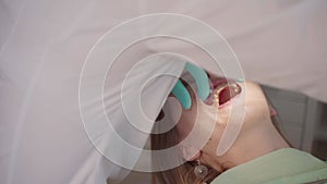 Female dentist removing braces patient teeth at dental clinic office. Medicine, dentistry concept. Dental equipment