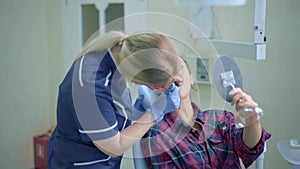 Female dentist showing for the patient result of treatment