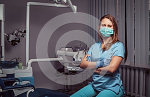 Female dentist sitting with her arms crossed in her dentist office.