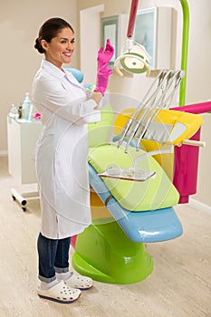 Female dentist standing next to a dentists chair