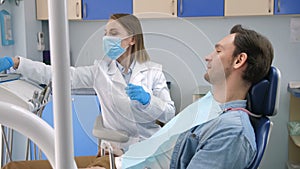 Female dentist starting check-up on male client