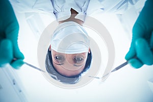 Female dentist in surgical mask holding dental tools