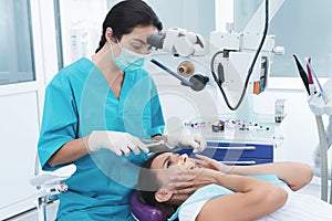 A female dentist is treating a patient. She sits on the dental chair and is afraid.