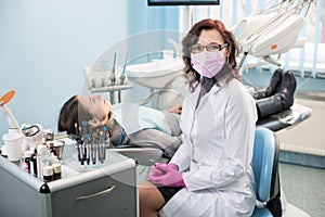 Female dentist with woman patient in the chair at the dental office