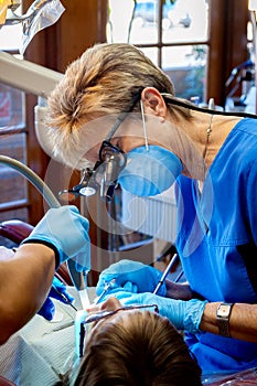 Female Dentist Working in the Mouth of a Kid