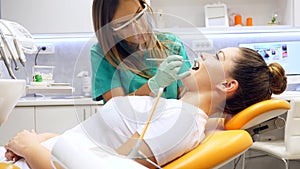 A female dentist working on a young woman`s teeth