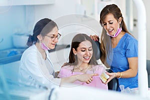 Dentists and patient in dentist office photo