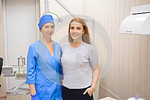 Female dentists treating patient. Doctor in uniform checking up female patient& x27;s teeth in dental clinic.