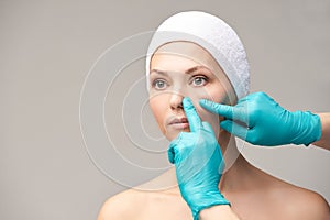 Female derma rejuvenate treatment. Doctor in gloves touch woman face. Cosmetology pretty portrait. Facial nosr injection patient